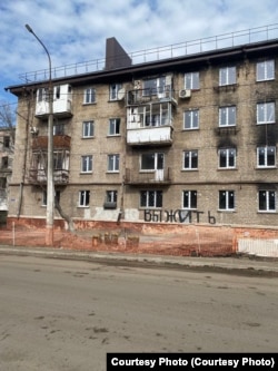 Один из обгоревших домов в Мариуполе с новыми стеклопакетами, фото сделано в марте 2023 года