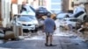 A man walks next to piled up cars following deadly floods in Sedavi, south of Valencia, eastern Spain, on October 30, 2024.